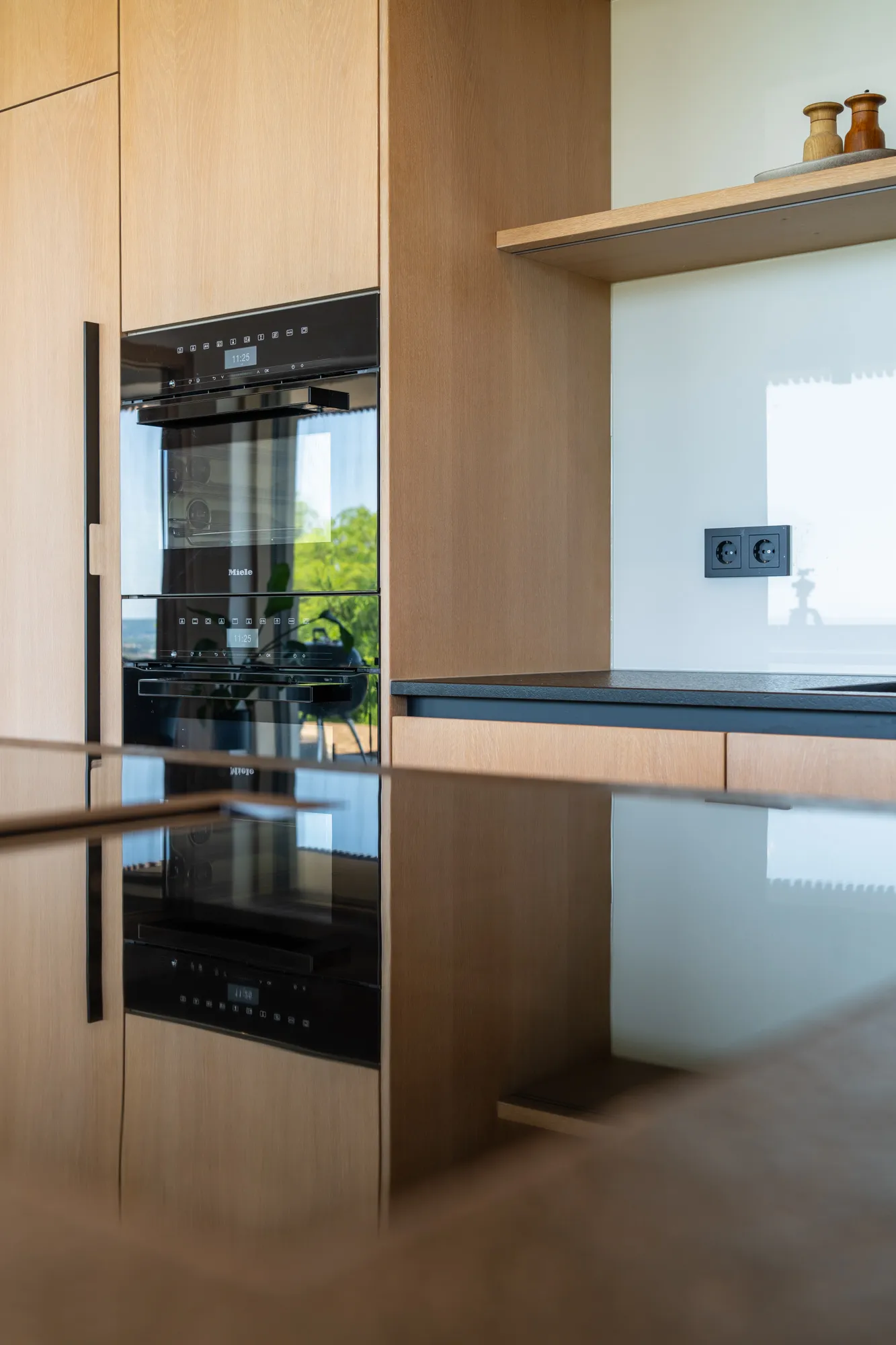 Edle Einbauküche aus Eichenholz mit schwarzen Akzenten und Miele Geräten von Deutschmann