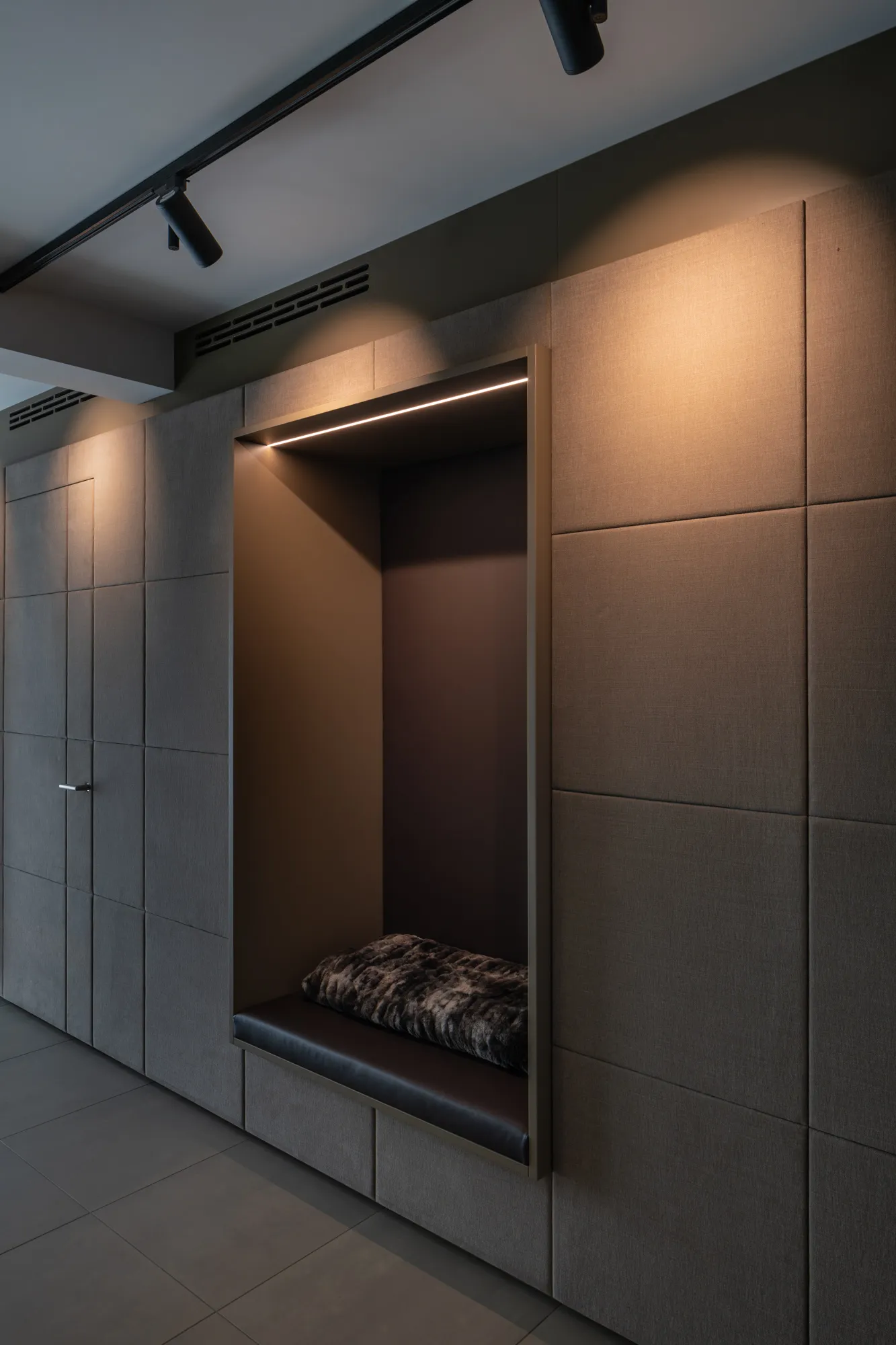 Moderner Eingangsbereich mit gepolsterter Sitznische und stimmungsvoller Beleuchtung von Deutschmann