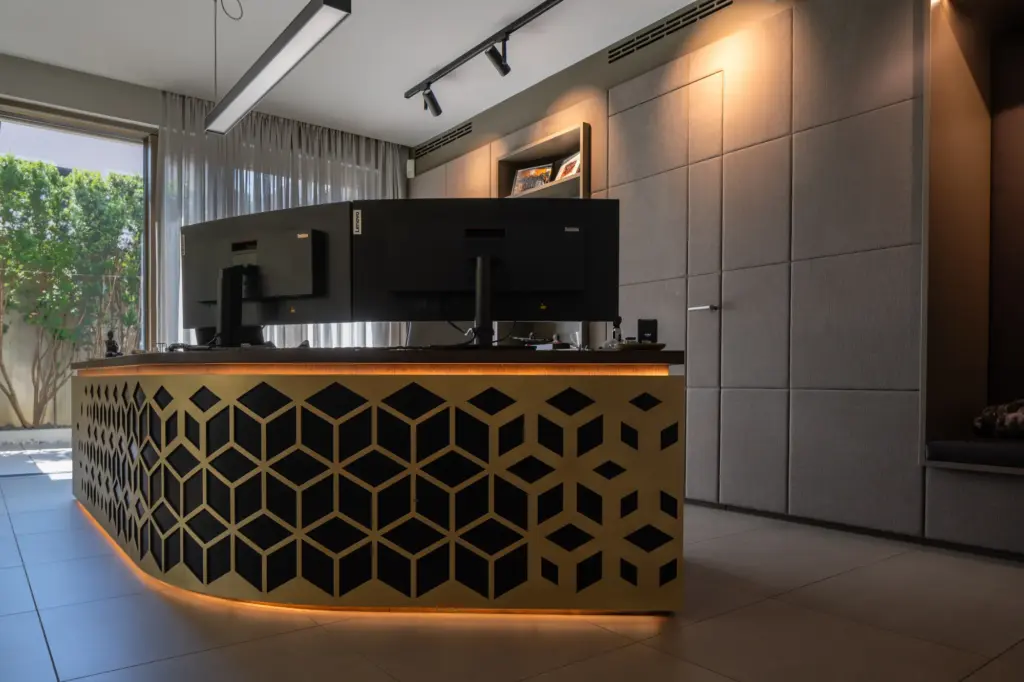 Moderner Arbeitsplatz mit geometrisch gestalteter Front in Gold und Schwarz umgesetzt von Deutschmann