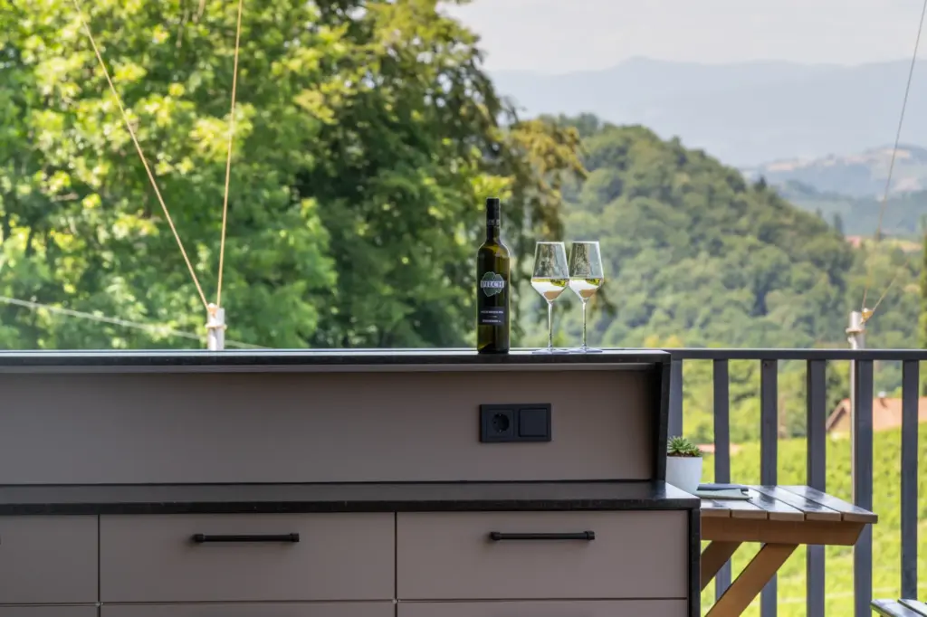 Elegante Outdoorküche mit schwarzen Griffen und minimalistischen Fronten gefertigt von Deutschmann