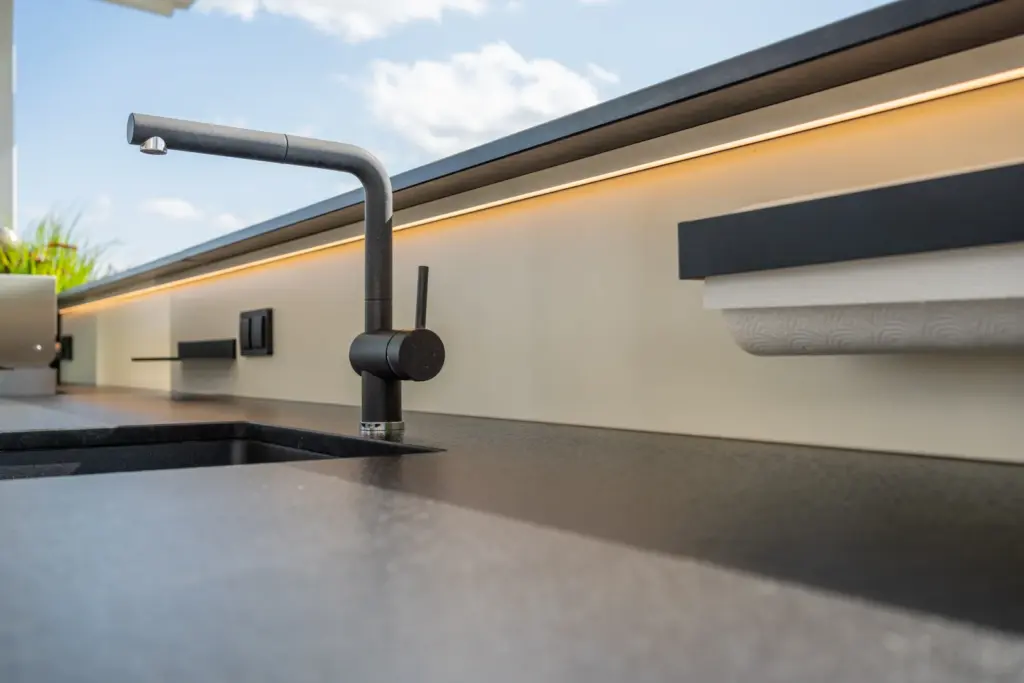 Detailansicht moderner Wasserhahn und Arbeitsfläche einer Outdoorküche gefertigt von Deutschmann