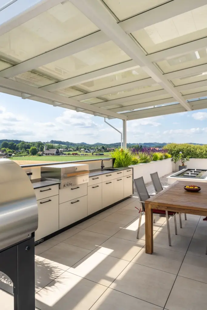 Terrasse mit moderner Outdoorküche und Sitzgruppe gefertigt von Deutschmann