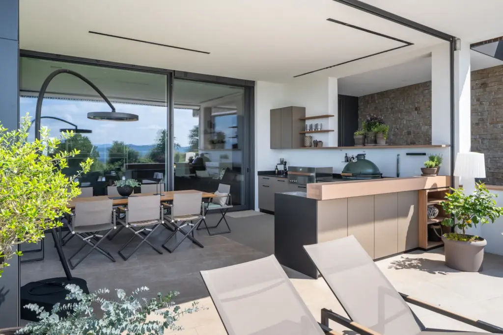 Großzügige Outdoorküche mit Sitzbereich und Blick in die Natur gestaltet von Deutschmann