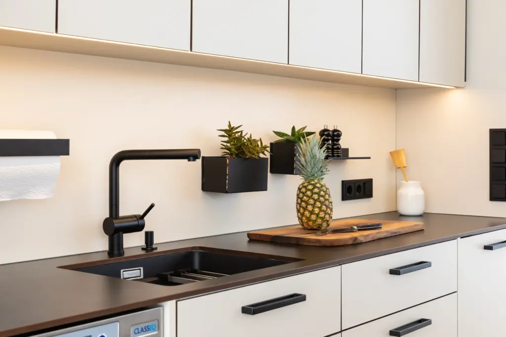 Spüle mit schwarzer Armatur und Arbeitsfläche in einer maßgefertigten Outdoorküche von Deutschmann