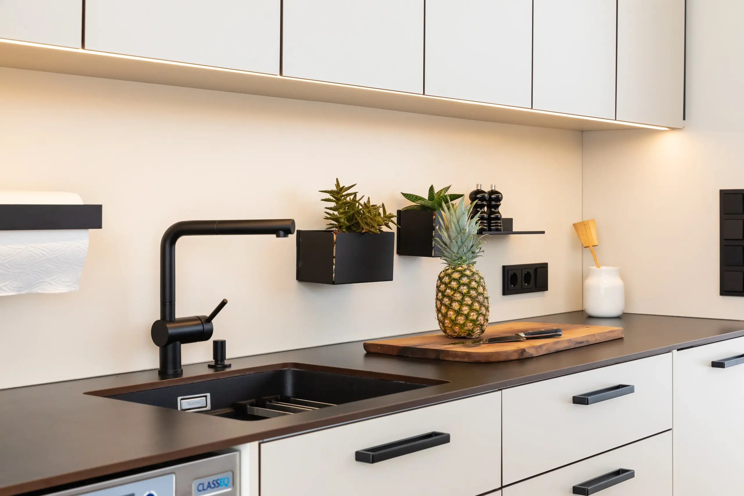 Spüle mit schwarzer Armatur und Arbeitsfläche in einer maßgefertigten Outdoorküche von Deutschmann