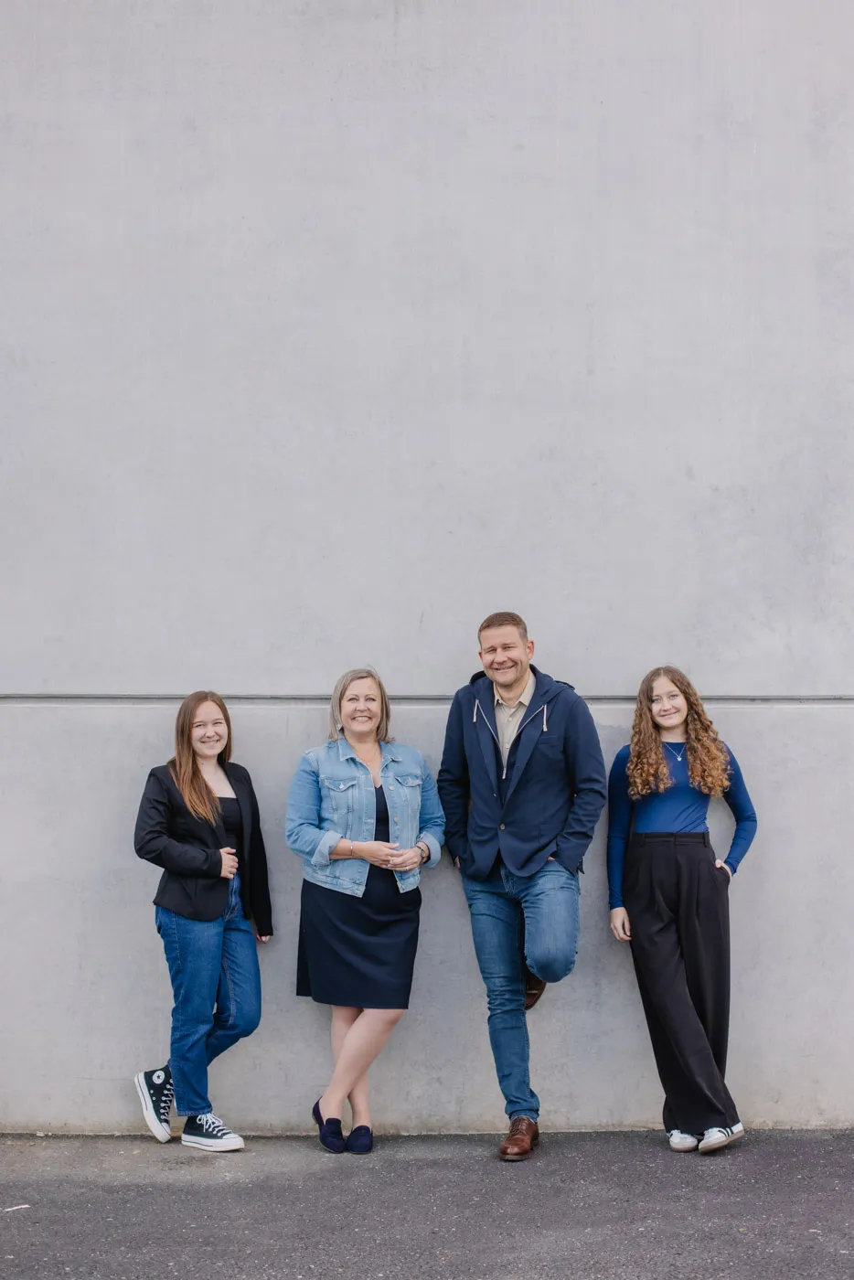 Familienportrait der vierten Generation von Deutschmann vor der grauen Werkstattswand