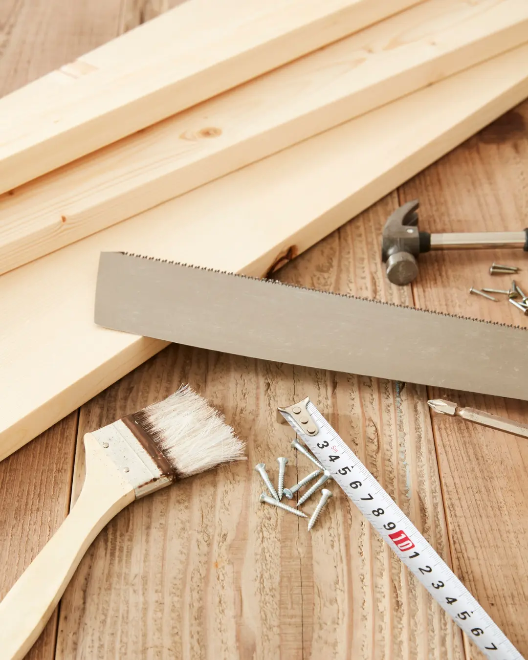 Werkbank mit Säge, Pinsel und Zollstock