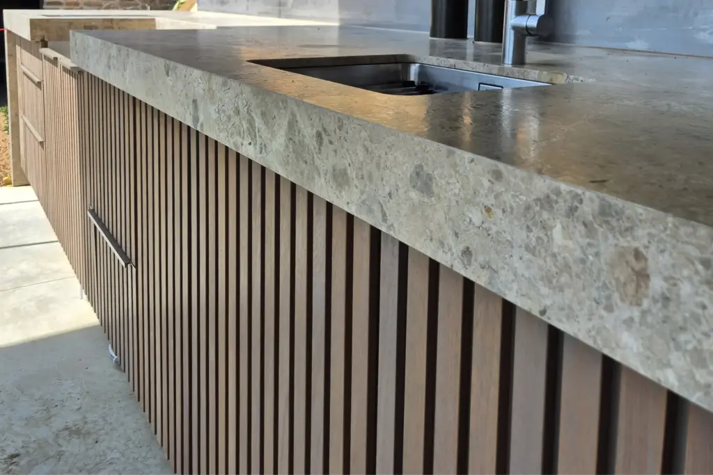 Front mit vertikalen Holzlamellen und Steinplatte für maßgefertigte Outdoorküchen von Deutschmann