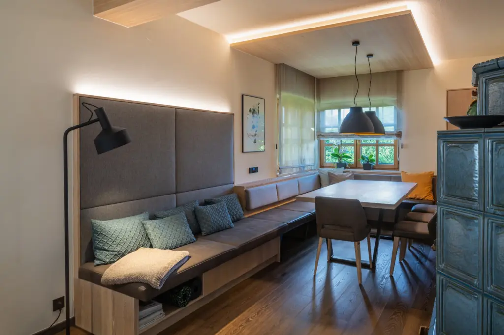 Gemütliche Sitzecke mit gepolsterter Eckbank Esstisch und Pendelleuchten in modernem Wohnraum von Deutschmann