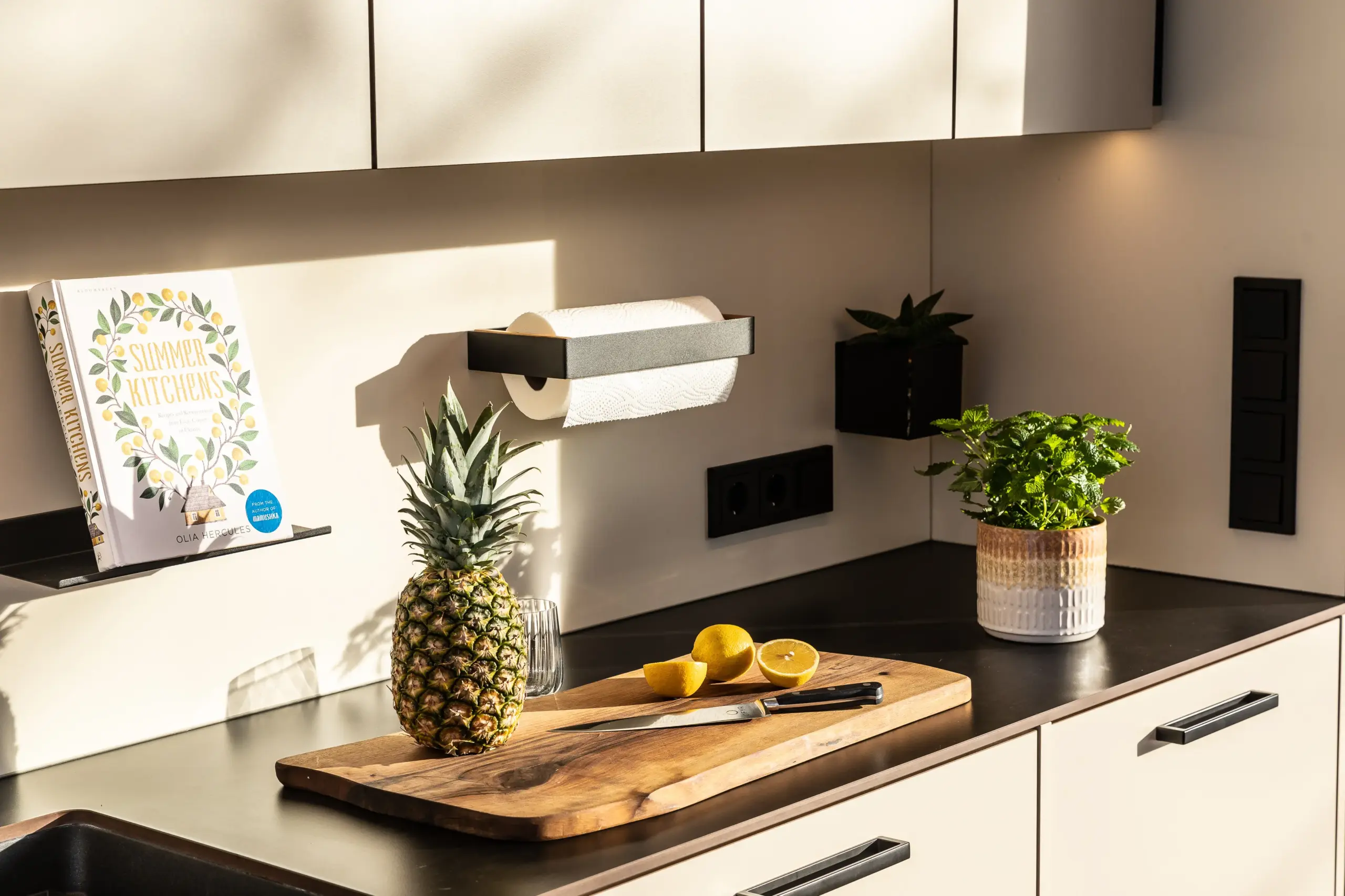 Detailaufnahme einer Deutschmann Outdoorküche mit Arbeitsfläche, darauf Brett mit Ananas, Zitronen und Kräutern