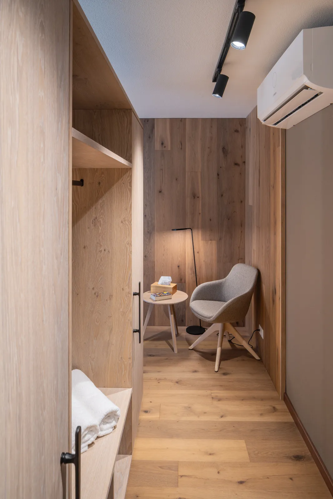 Maßgefertigte Garderobe und Sitzecke aus Holz von Deutschmann im warmen Eingangsbereich