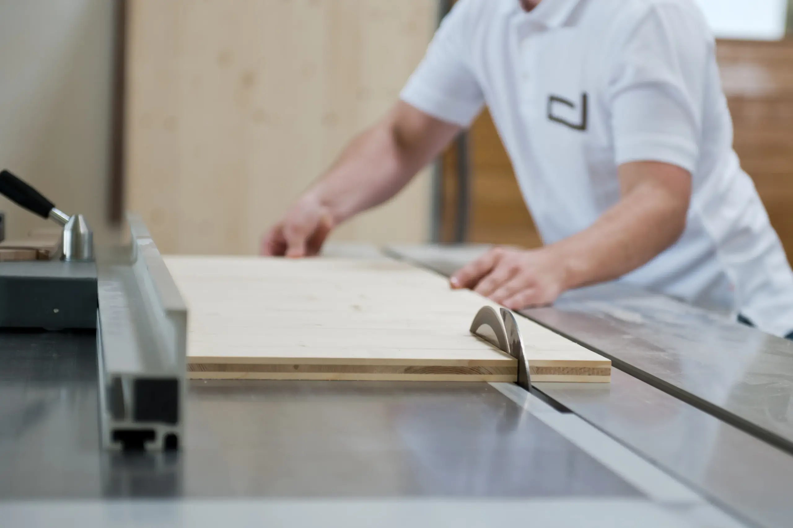 Tischler schneidet präzise Holzplatte an Kreissäge in der Werkstatt von Deutschmann