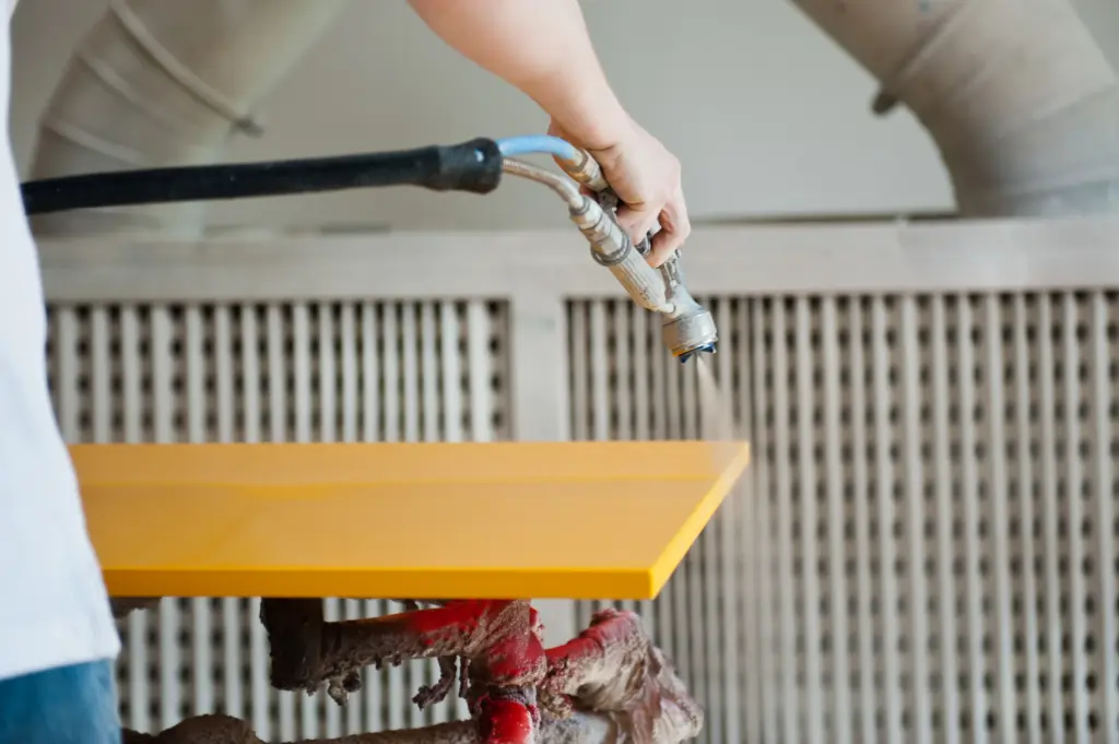Lackierung eines Möbelstücks in gelb in der Werkstatt von Deutschmann Moebel Handwerk
