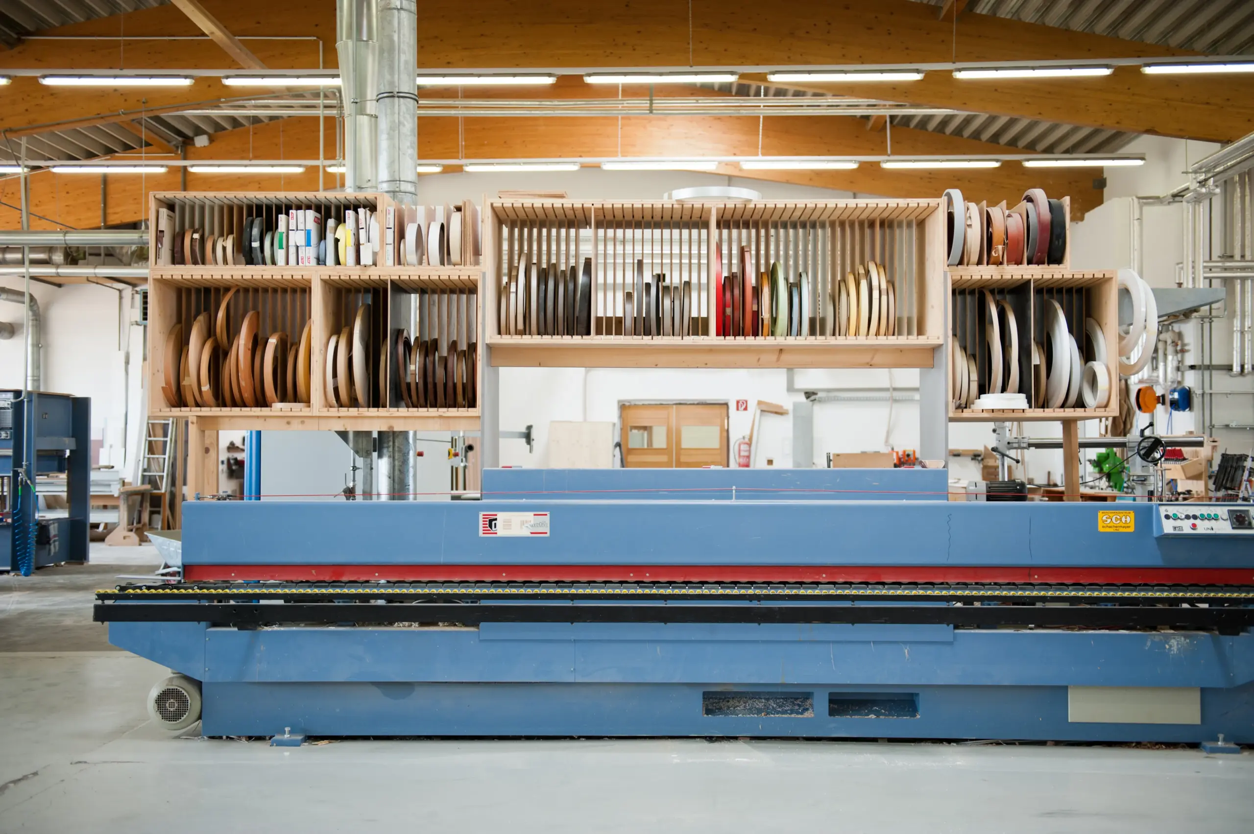 Blick in die Werkstatt von Deutschmann mit Furnierrollen und moderner Holzbearbeitungstechnik