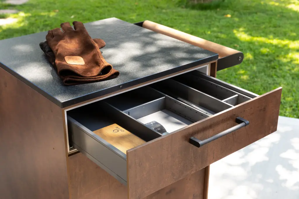 Detailansicht vom Beistellwagen von Deutschmann, offene Schublade mit Grillutensilien darin und einem OFYR