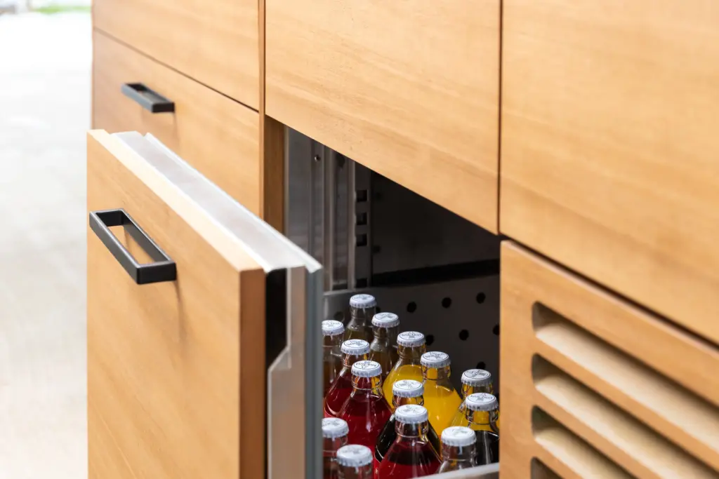 Detailansicht einer Kühllade der Outdoorküche von Deutschmann, gefüllt mit diversen Limonaden