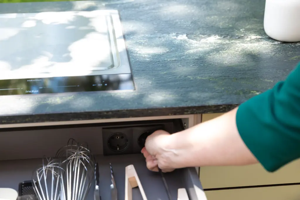 Nahansicht einer integrierten Steckdosen in der Schublade einer Outdoorküche von Deutschmann