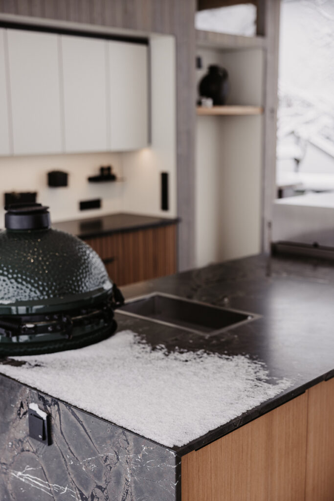 Deutschmann Outdoorküche mit leichten Schnee bedeckt und Big Green Egg Grill integriert