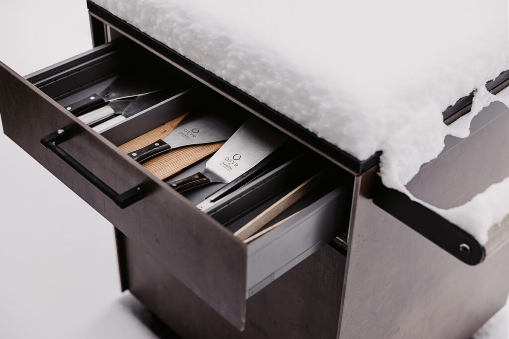 Detailansicht vom Beistellwagen von Deutschmann, offene Schublade mit Grillutensilien darin, verschneite Arbeitsfläche
