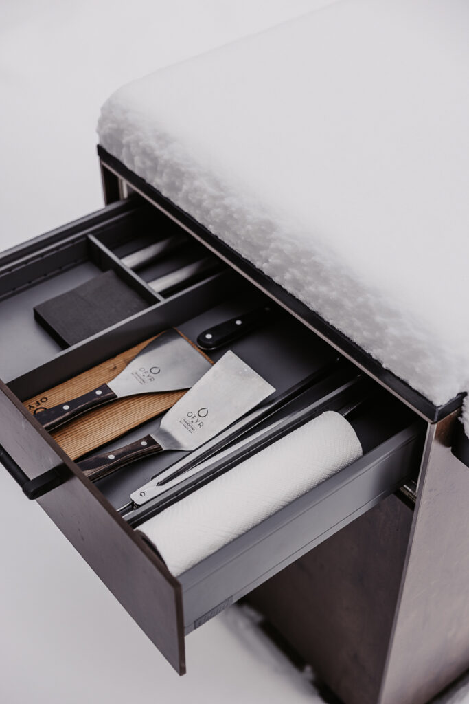 Detailansicht vom Beistellwagen von Deutschmann, offene Schublade mit Grillutensilien darin, verschneite Arbeitsfläche