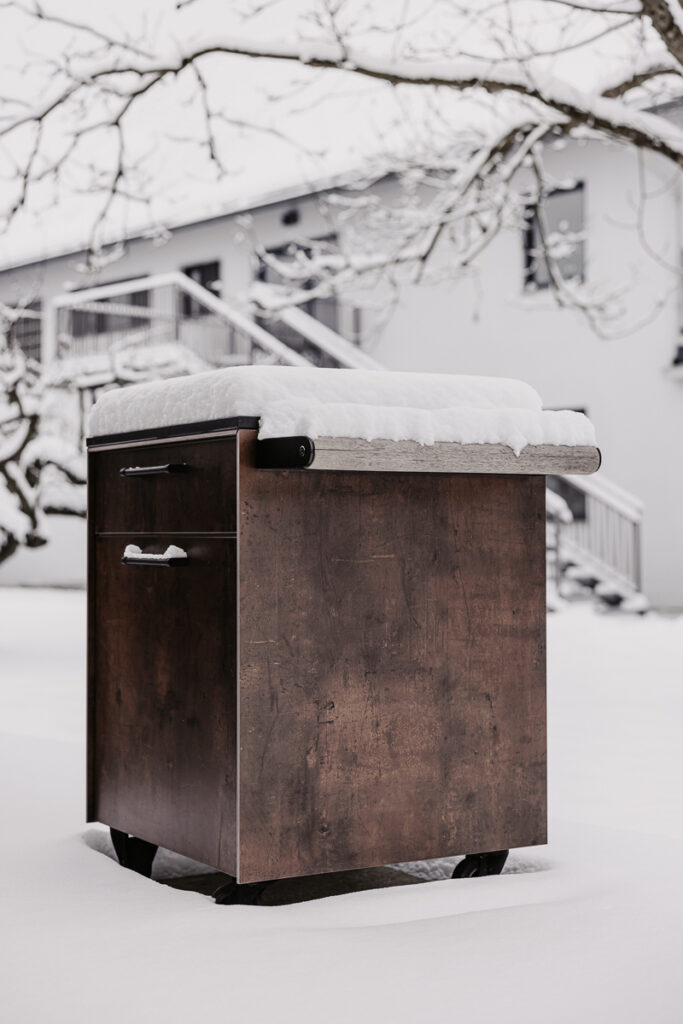 Deutschmann Beistellwagen mitten in Schneelandschaft und mit Schnee bedeckt