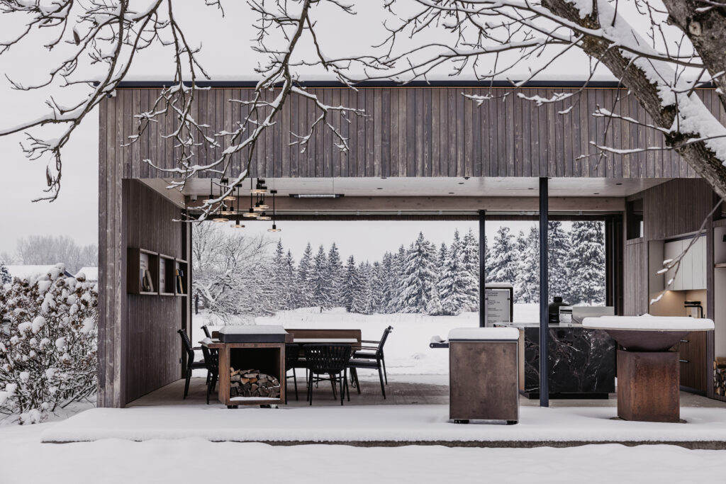 Deutschmann Outdoormöbel Ausstellung in verschneiter Landschaft, Essbereich, mit Beistellwagen, OFYR Grill und Outdoorküche