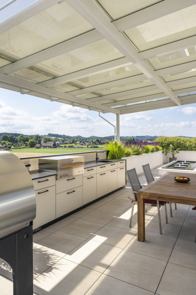 Wetterfeste Deutschmann Outdoorküche in hellen Farben mit Flammkraft Grill auf einer Terrasse