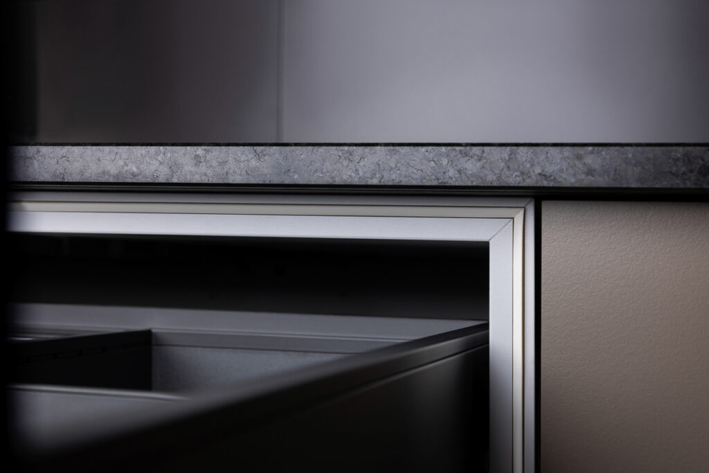 Detailansicht einer dunklen Outdoorküche, offene Schublade mit Detail auf Dichtungen